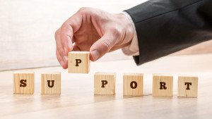 Close up Hand of a Businessman Arranging Small Wooden Blocks on the Table for Business Support and Customer Service Concept.